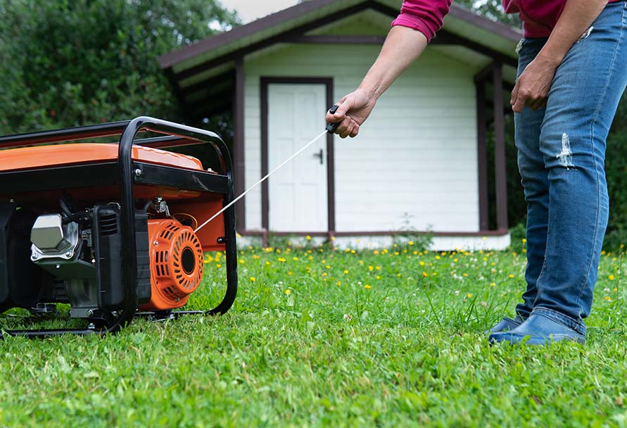 Close up of someone starting a generator in their yard