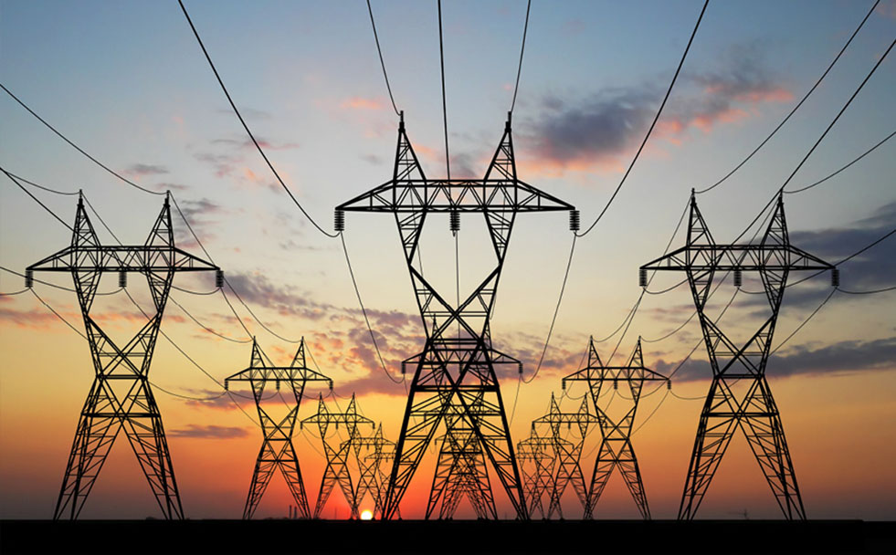 Electric transmission lines in front of a sunset.