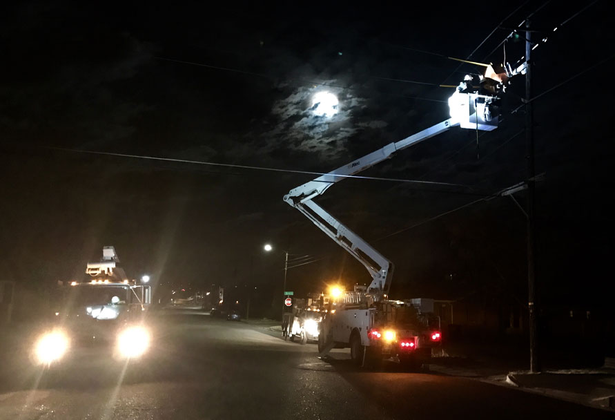 Bucket truck fixing a power line in the dark