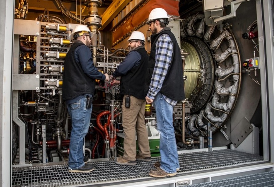 Three men working inside a power plant