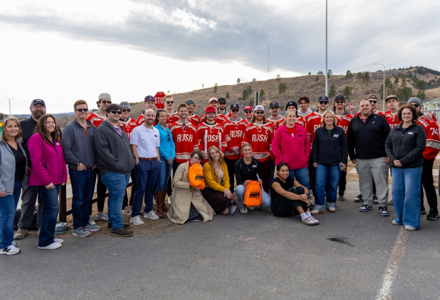Black Hills Energy employees along with Rapid City Rush players posing for a group photo
