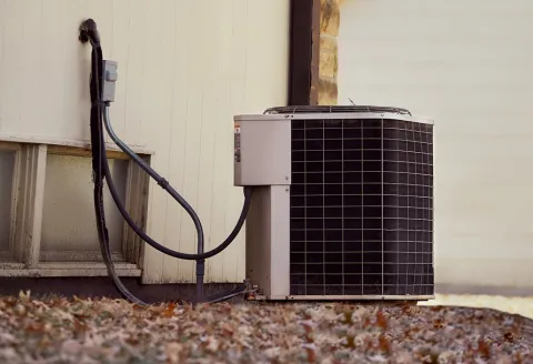 Image of an air conditioner unit outside of a house.