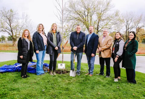Arbor Day celebration with group of people lined up for a photo after planting a tree